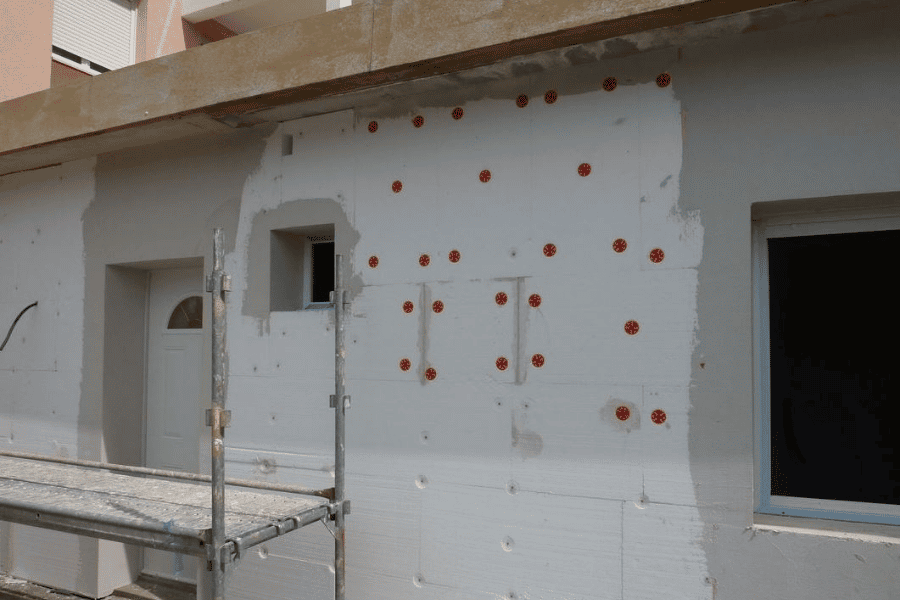 Chantier ITE façade avec panneaux polystyrène chevillés sur échafaudage à Orthez – Tuheil Établissement