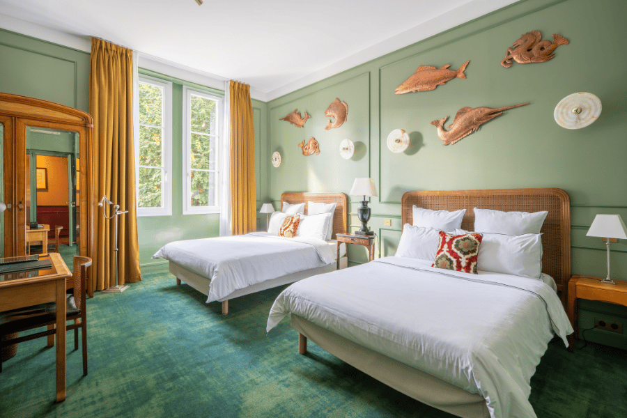 Revêtement de sol moquette verte et peinture murale vert sauge dans une chambre d'hôtel à Montardon – Tuheil Établissement