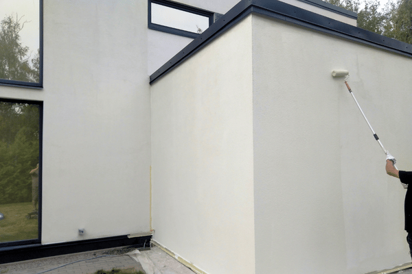 Application de peinture au rouleau sur façade enduite d'une maison contemporaine à Orthez – Tuheil Établissement