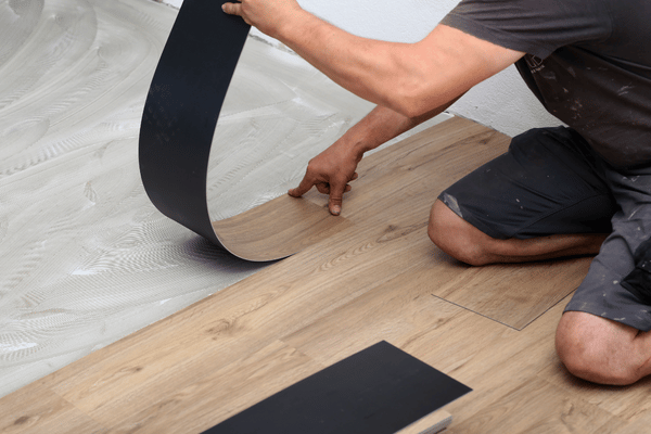 Pose de lames vinyles LVT imitation bois par un artisan à Montardon – Tuheil Établissement